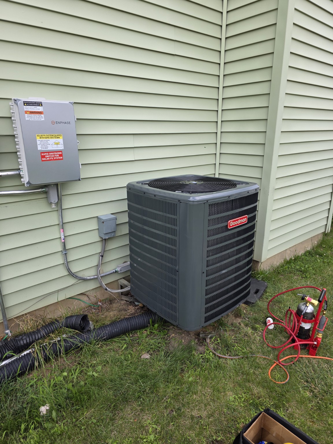 Goodman outdoor condenser installation beside a home